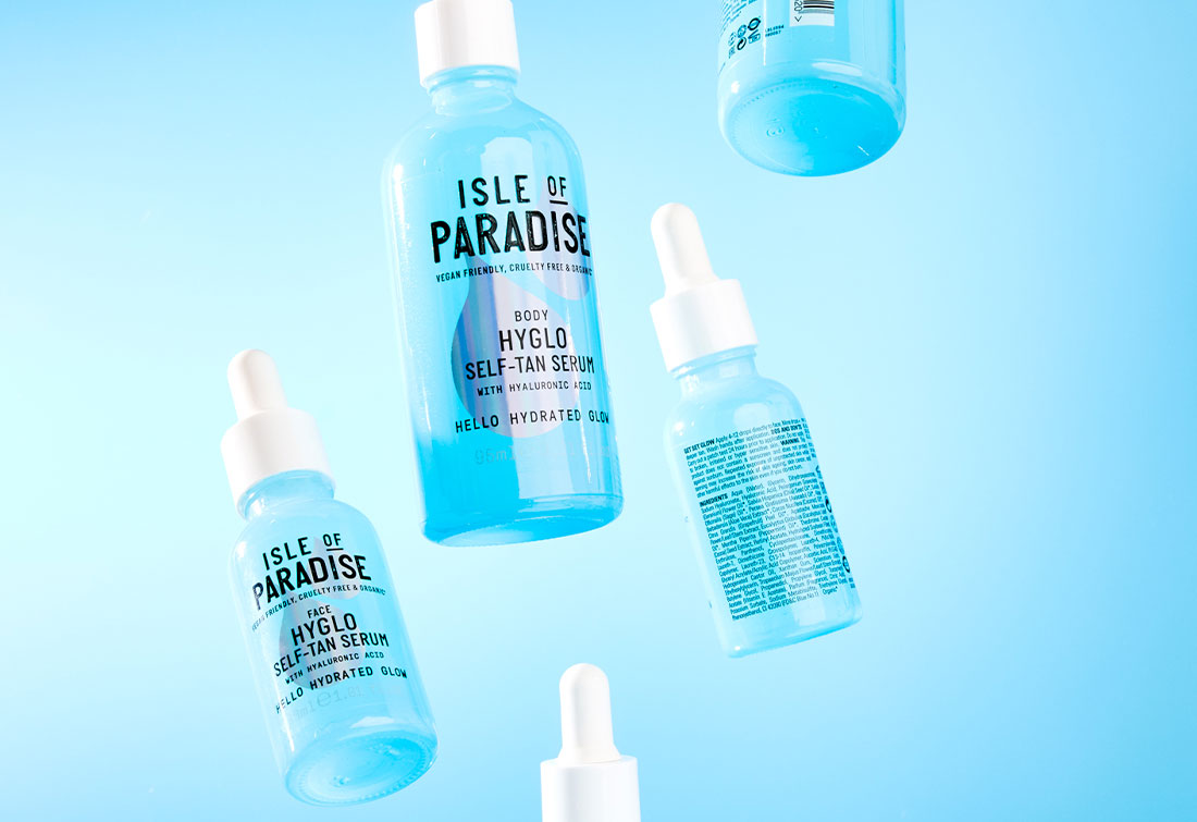 Hyglo self tan serum bottles floating in mid air on blue background